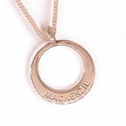 A rose gold personalised pendant that has a name on it.